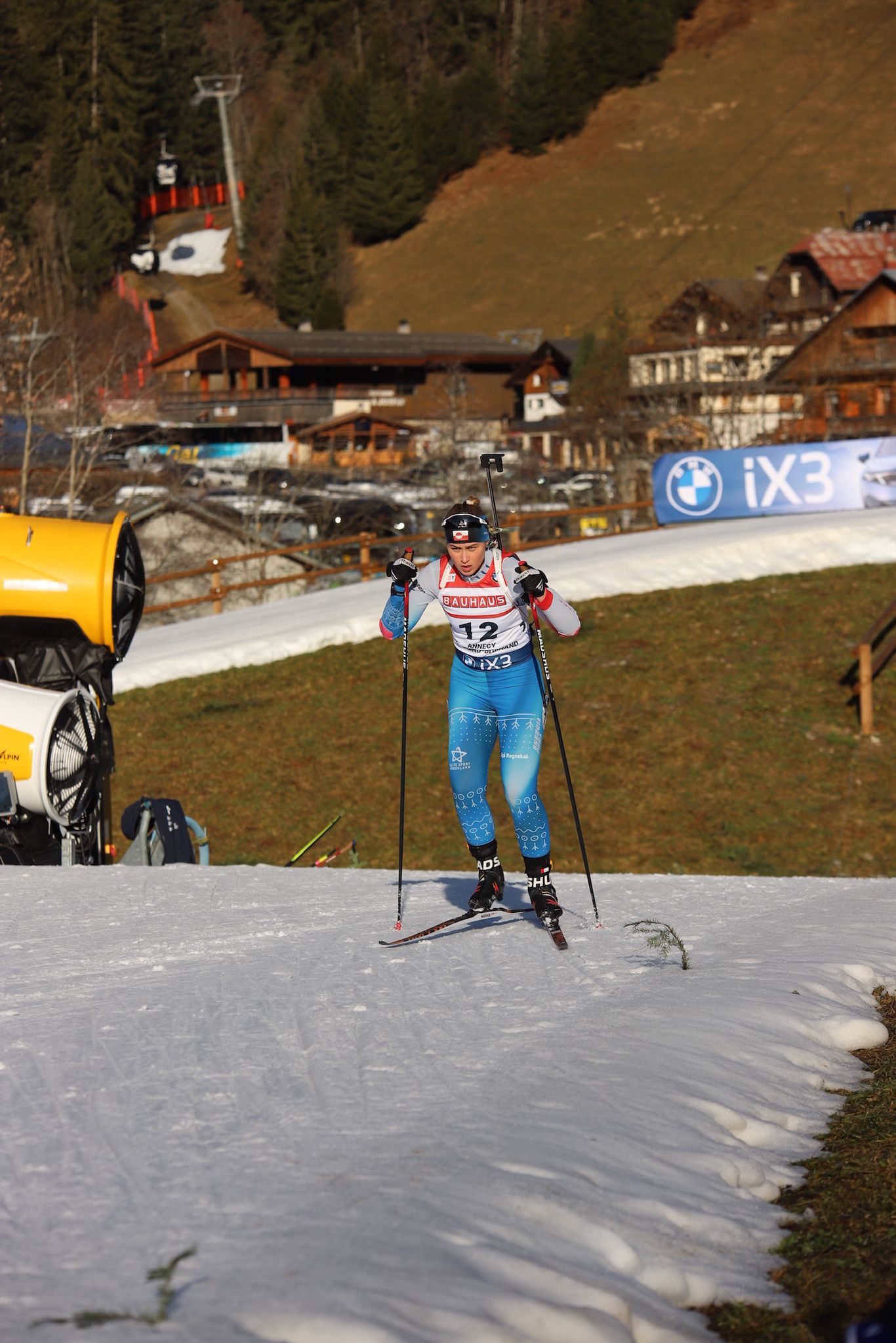 Ukaleq Slettemark skis uphill on a narrow strip of snow. Behind her you can see a hillside without snow. 