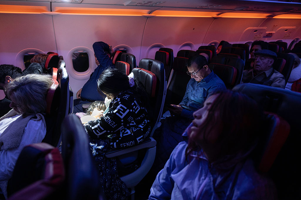 28歲的無證母親Andrea（左）和22歲的表妹Jennyfer（右）於2025年10月27日在從甘迺迪國際機場飛往厄瓜多的夜間航班上睡覺。